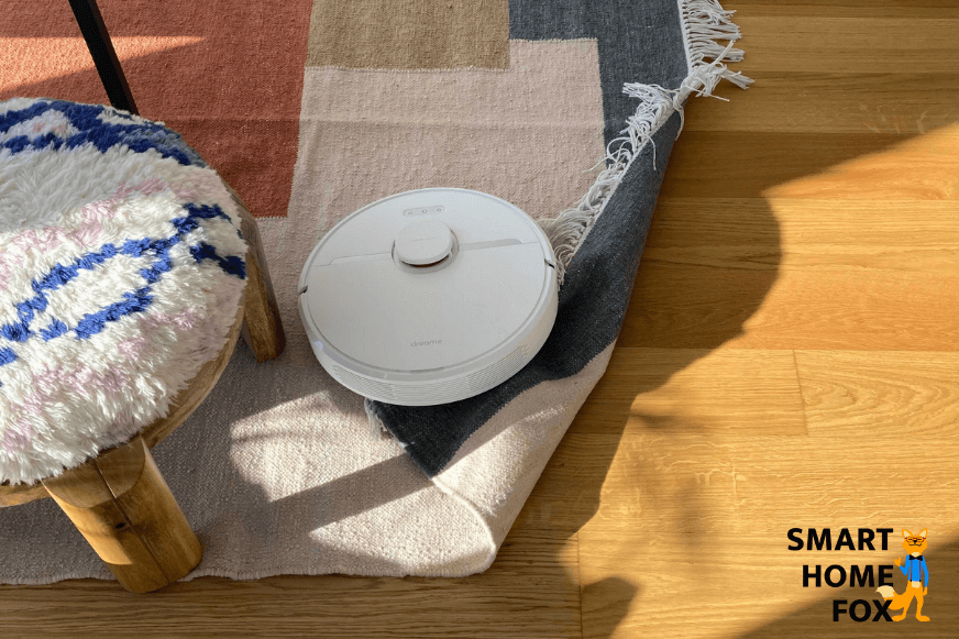 Saugroboter klappt einen sehr leichten Teppich bei der Reinigung um